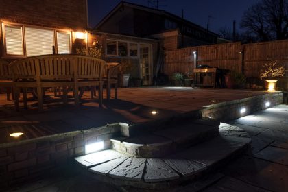 Garden light scene including wall lights, patio uprights step lights and in the background downlights attached o the fence in a garden in Faversham 