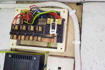 Picture 2: Image of orginal fuse board in process of being removed. You can see the exposed electrical wires. 